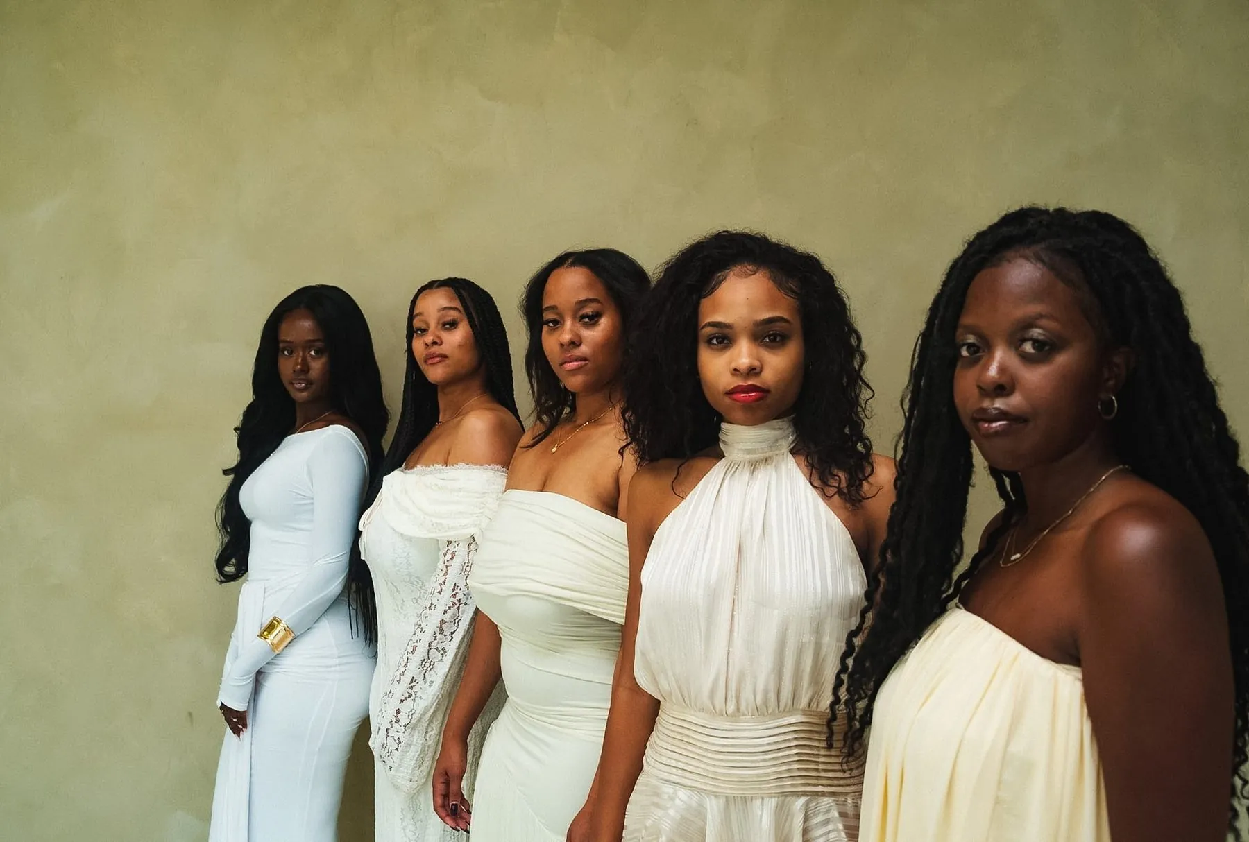 The five women of Redeemed, Vol. 1, standing together in white